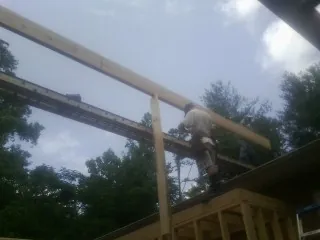 Carpenter setting a ridge beam over a new addition frame — Ice Dam Removal by Roofing Brothers in Faribault