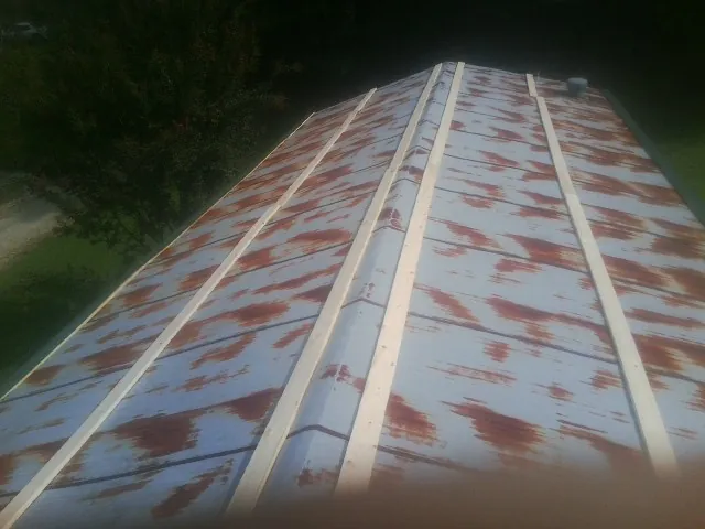 Rusted metal roof panels with new wood purlins before replacement — Storm Damage Roof Repair in Faribault by Roofing Brothers